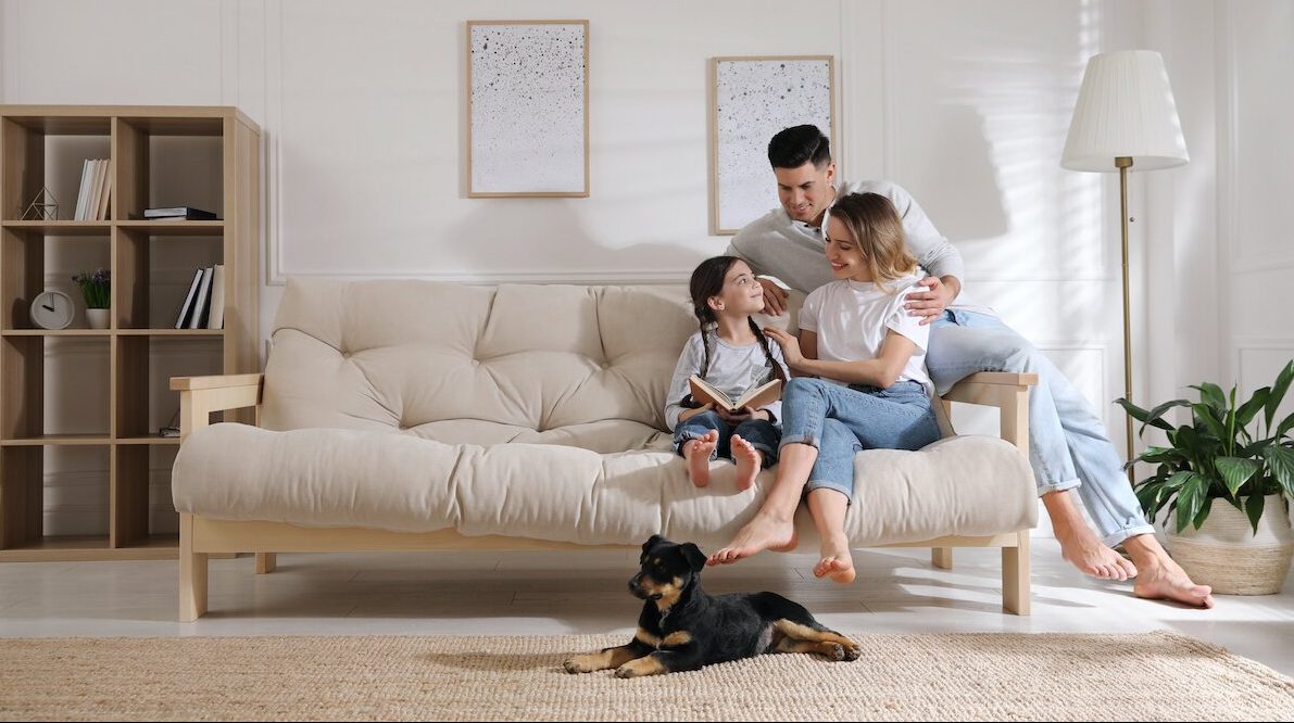 Happy family on sofa and puppy in living room