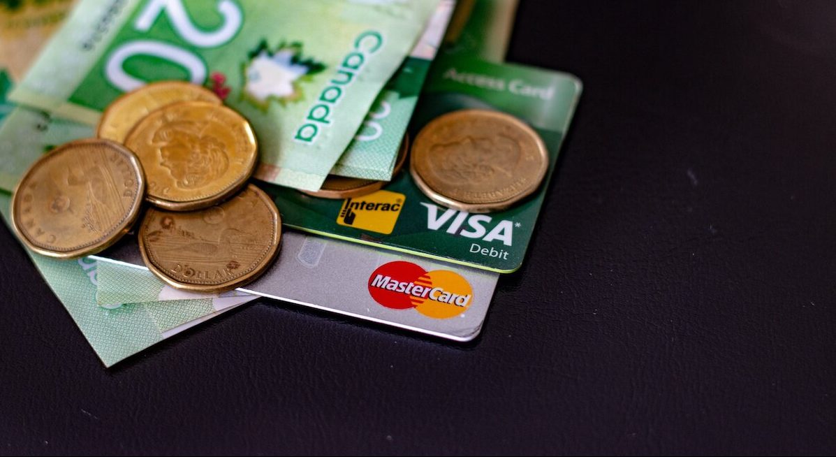 Canadian cash laying on debit and mastercard