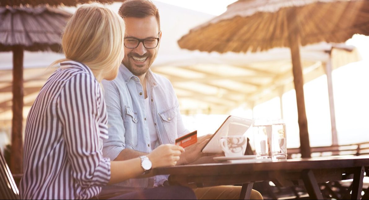 A young couple using a no foreign transaction fee credit card while on vacation